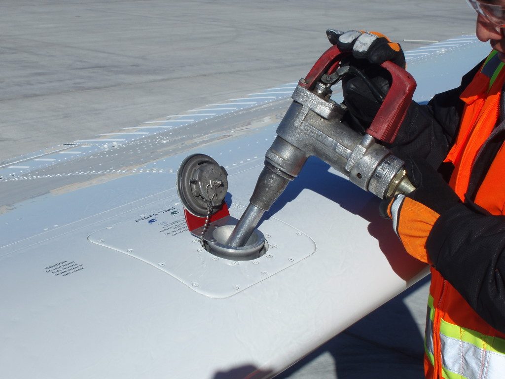 Abastecimiento de aeronave por sobre el ala con pistola de carguío y protector de ala